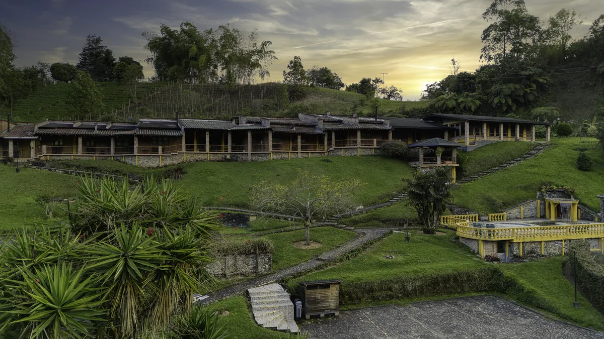 La finca al atardecer: la hilera de habitaciones y los jardines aterrazados